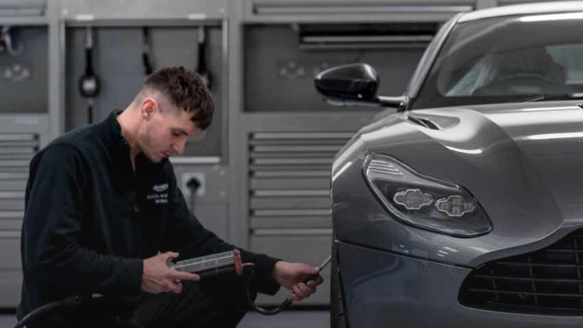 Technician checking air pressure on Aston Martin Tire